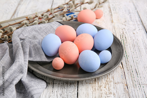 Plate with beautiful Easter eggs on wooden background