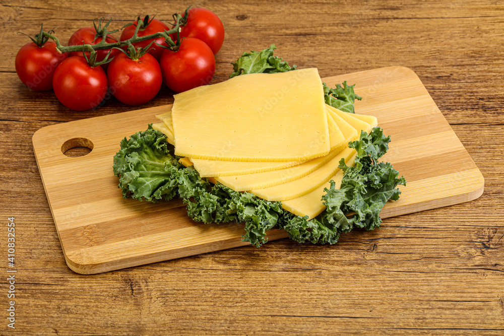 Sliced Gauda cheese over board Sliced Gauda cheese over board