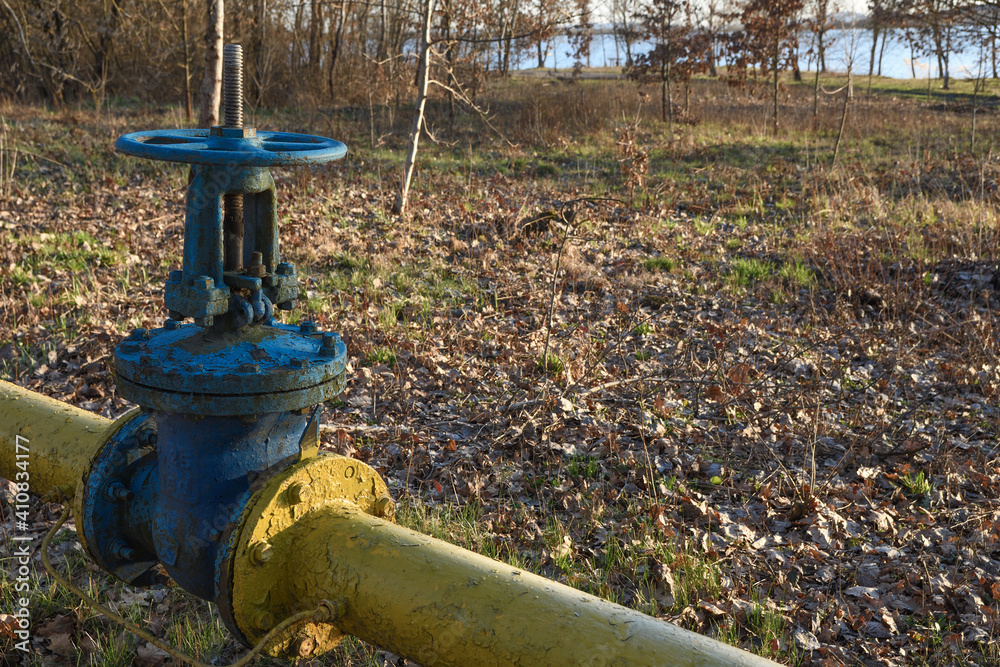 Old gas pipes with large overlapping taps are laid underground in the yard.