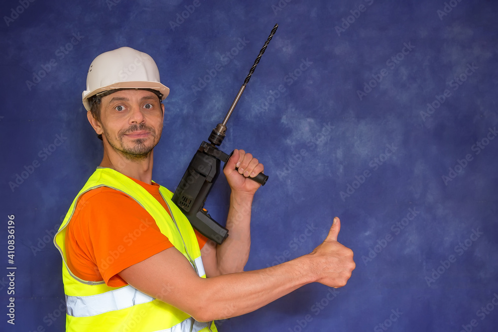 Male locksmith, builder. A worker with a tool in his hands and in working uniform. Male locksmith, builder. A worker with a tool in his hands and in working uniform.