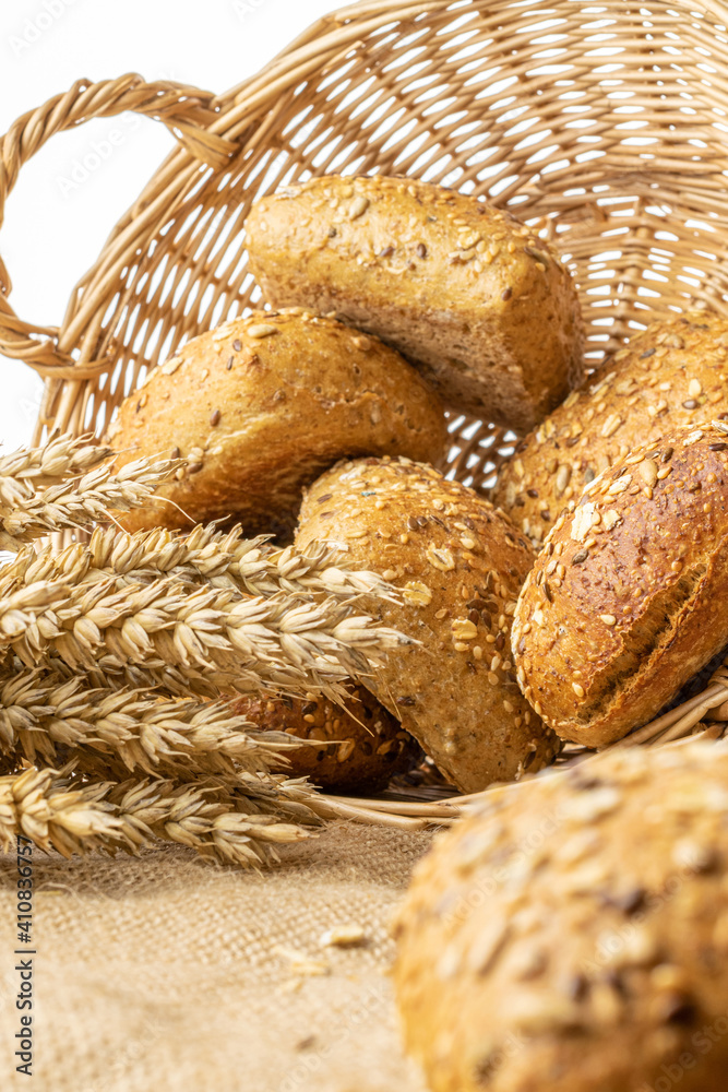 Home baked bread. Rye bakery with crusty loaves and crumbs. Fresh rustic traditional bread with wheat grain ear or spike plant on natural cotton background. Design element for bakery product label.