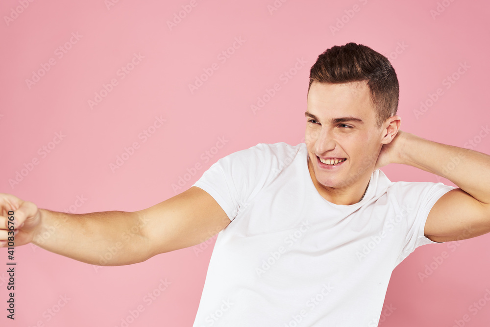 Cheerful handsome man in white t-shirt emotions pink isolated background