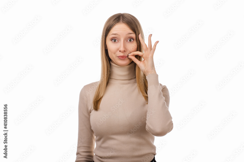 Blond girl in casual clothes showing zip gesture as if shutting mouth on key. Keep a secret Blond girl in casual clothes showing zip gesture as if shutting mouth on key. Keep a secret