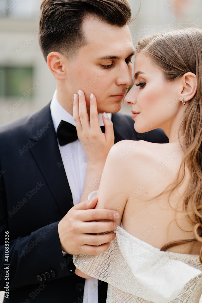 Naklejka premium beautiful, gentle and happy bride and groom. woman gently touches man's face