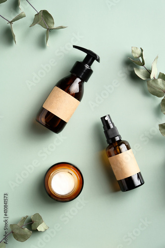 Natural organic SPA cosmetic products set with eucalyptus leaves. Top view herbal skincare beauty products on green background. Vertical banner for eco shop or beauty salon