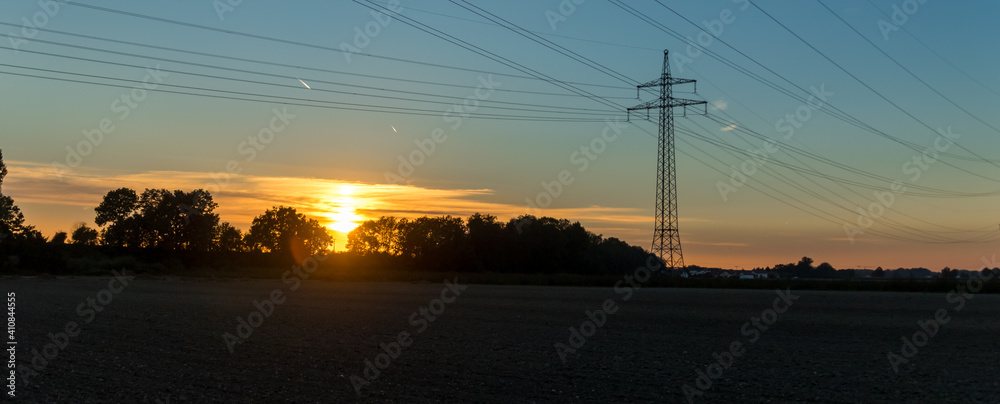 Beautiful sunset with overland high voltage lines near Tabertshausen, Bavaria, Germany