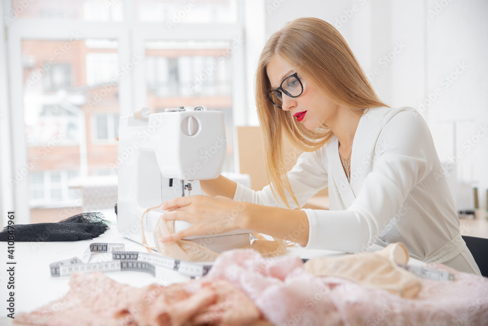 Young fashion designer of women underwear works sewing machine Young fashion designer of women underwear works sewing machine