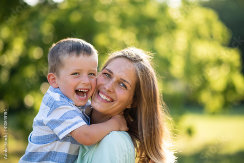 Cheerful mother and child posing with bright smile