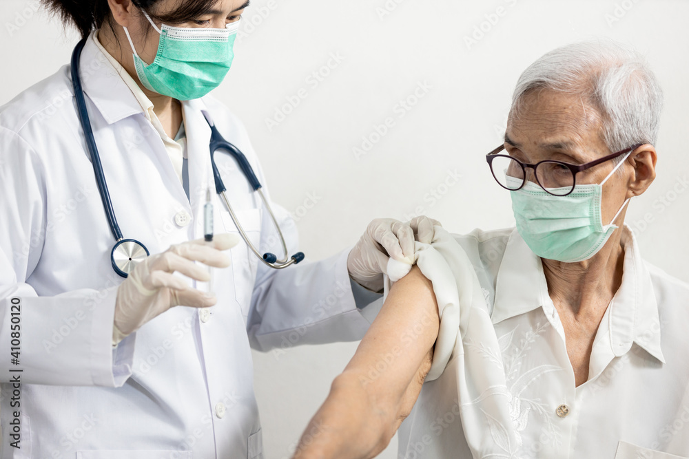 Asian nurse use cotton ball with alcohol to clean the shoulder of old elderly before vaccination Coronavirus,female doctor holding syringe containing COVID-19 vaccine,preparing an injection for senior Asian nurse use cotton ball with alcohol to clean the shoulder of old elderly before vaccination Coronavirus,female doctor holding syringe containing COVID-19 vaccine,preparing an injection for senior