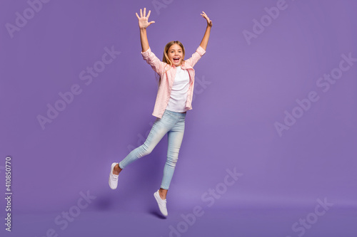 Full size photo of hooray pretty girl jump wear pink shirt jeans sneakers isolated on violet background