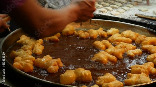 Taking delicious Patonggo out from hot oil at street food stall. photo