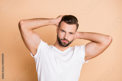 Photo of young handsome man serious enjoy haircare shampoo conditioner isolated over beige color background