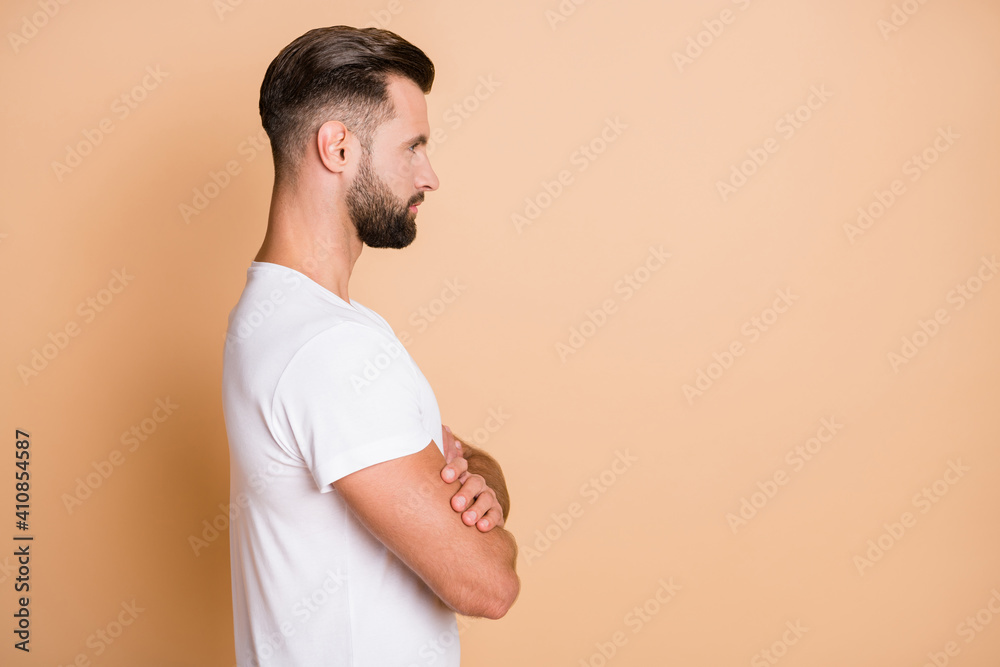 Profile side view portrait of serious virile guy folded arms copy empty blank place space isolated over beige pastel color background Profile side view portrait of serious virile guy folded arms copy empty blank place space isolated over beige pastel color background