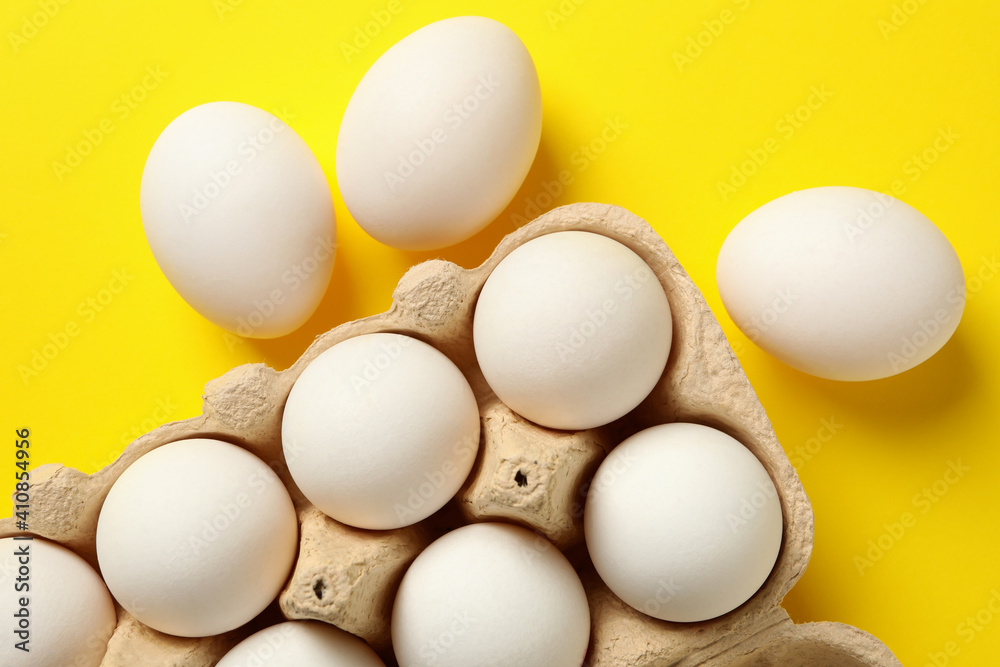Egg box with fresh eggs on yellow background Stock Photo | Adobe Stock
