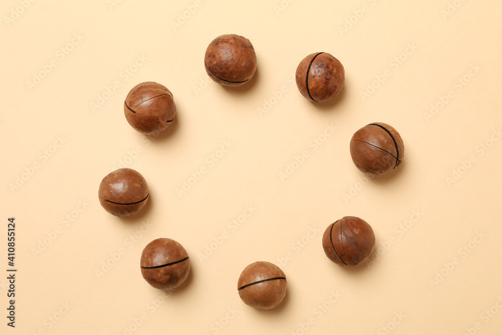 Tasty macadamia nuts on beige background, space for text Tasty macadamia nuts on beige background, space for text
