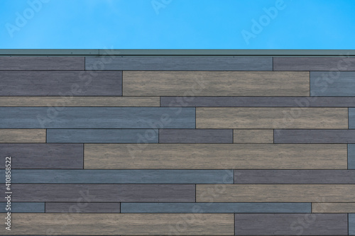 Modern horizontal planking in gray, brown and beige tones on a building.