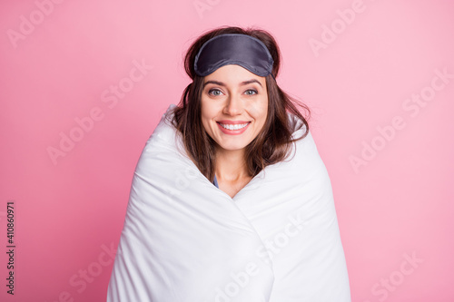 Photo portrait of woman wrapped in bed sheets isolated on pastel pink colored background
