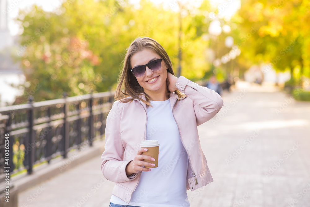 Portrait of a young, happy and pretty blonde girl with a cup of coffee in her hands