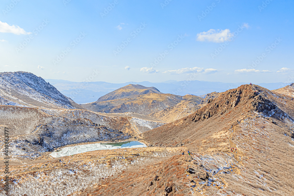 冬の中岳山頂から見たくじゅう連山と凍結した御池　大分県玖珠郡　Kuju mountain range and 
Frozen pond seen from the summit of Nakadake in winter Ooita-ken Kusu-gun