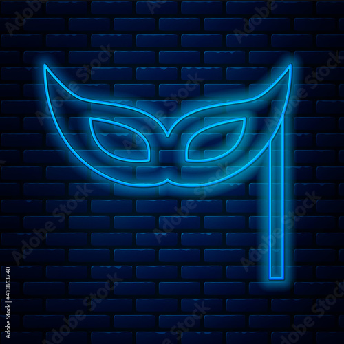 Glowing neon line Festive mask icon isolated on brick wall background. Merry Christmas and Happy New Year. Vector.