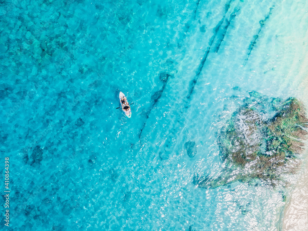 Kayakers on kayak floating in blue transparent sea. Aerial view