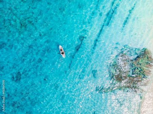 Kayakers on kayak floating in blue transparent sea. Aerial view