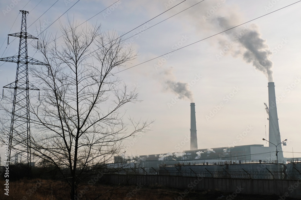 Almaty, Kazakhstan - 02.04.2021 : Power lines on the background of the building of the main heating plant with smoking pipes