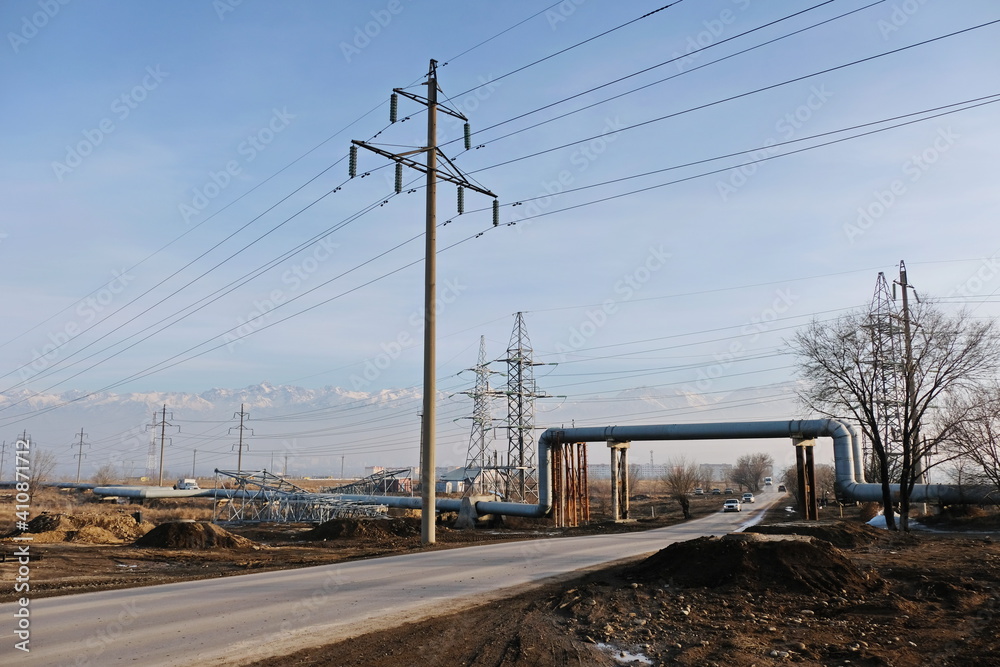 Almaty, Kazakhstan - 02.04.2021 : The road along the power lines and pipes of the heating plant