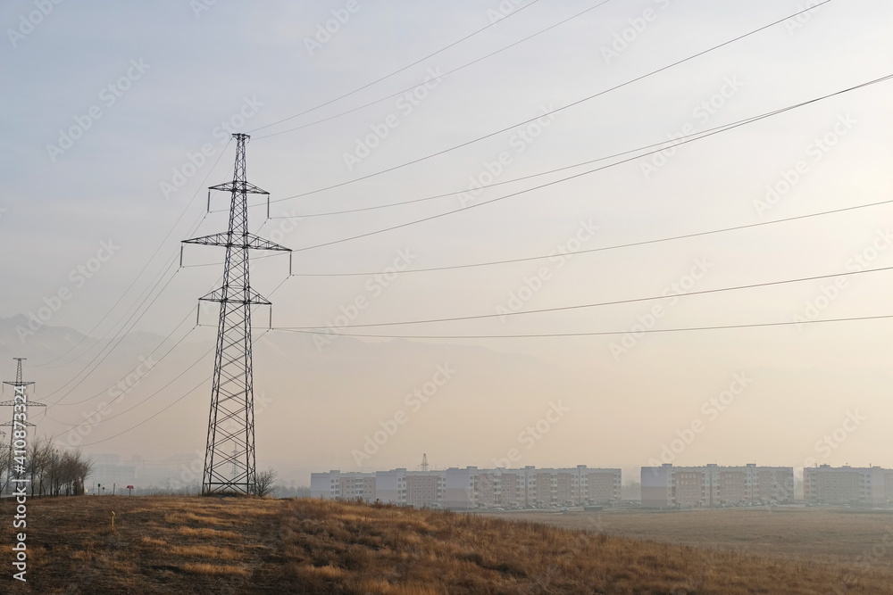 Almaty, Kazakhstan - 02.04.2021 : Power lines on the background of houses covered with a layer of smog Almaty, Kazakhstan - 02.04.2021 : Power lines on the background of houses covered with a layer of smog