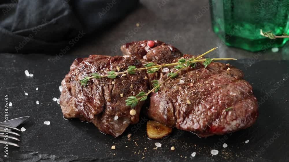 pepper falling on freshly grilled beef fillet steak meat on black stone restaurant plate pepper falling on freshly grilled beef fillet steak meat on black stone restaurant plate