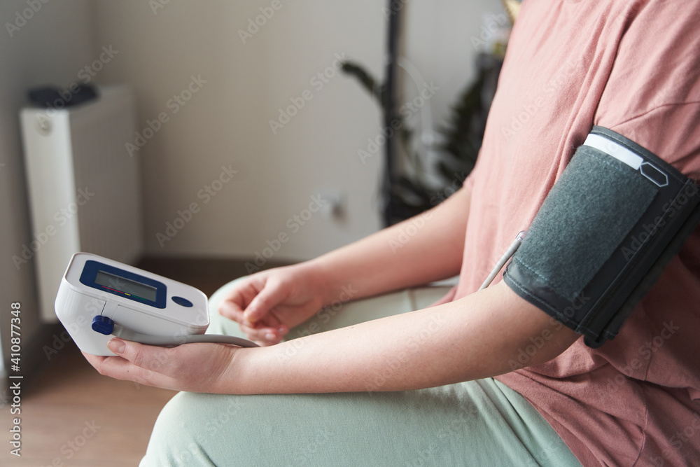 Fototapeta premium Selective focus girl is taking care for health with hearth beat monitor and blood pressure and heart rate monitor with digital pressure gauge. Health care and Medical concept. The topic of high blood