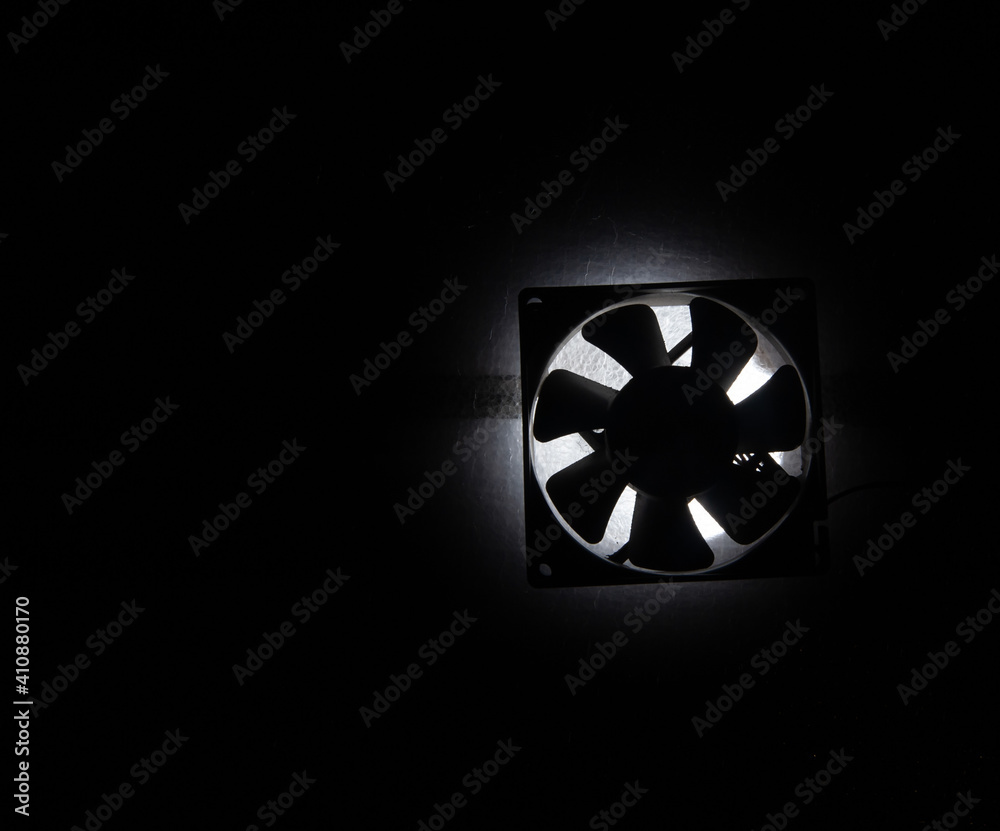 an old fan glows from within in the dark an old fan glows from within in the dark