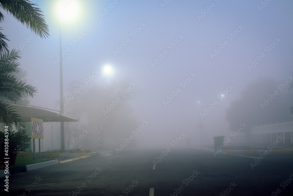 Road in the fog, sign mention keep distance for motorists at dubai road, foggy weather in UAE, Dense Fog keep Safe Distance banner in arabic and english