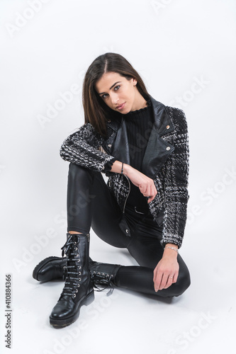Portrait of Beautiful woman in black leather pants and high boots sitting