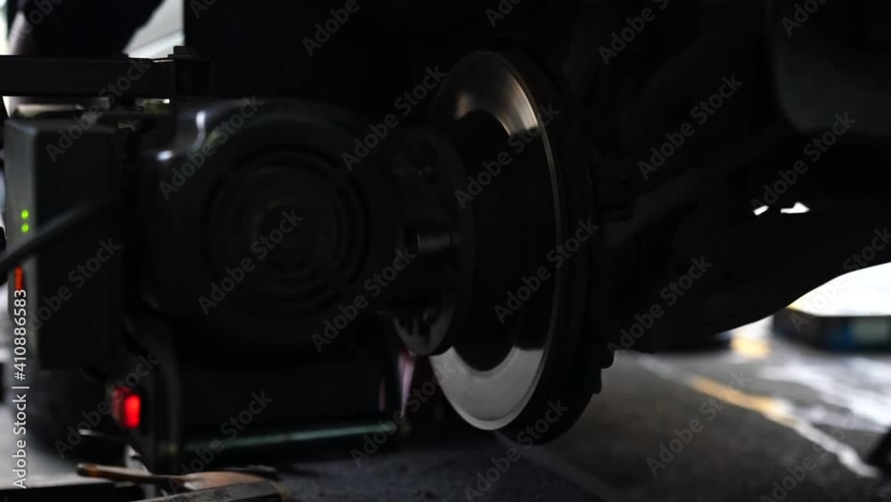 Cleaning disc brake. A car mechanic repairing the brakes. Mechanic man repairing brake use lathe tool polishing disc brakes of cars working automatic. Cleaning disc brake. A car mechanic repairing the brakes. Mechanic man repairing brake use lathe tool polishing disc brakes of cars working automatic.
