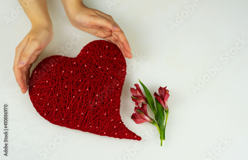  Heart of red threads of yarn in female hands