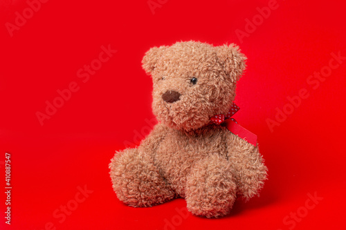 teddy bear with red ribbon on red background