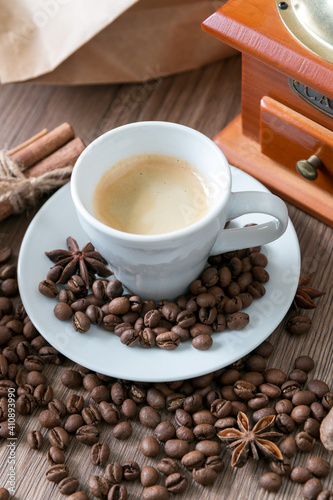 Cup of coffee with coffee beans and coffee grinder on table 