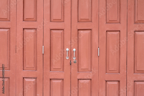 A red color folding door, a vintage wood door. Thai style wooden wall in Thai house