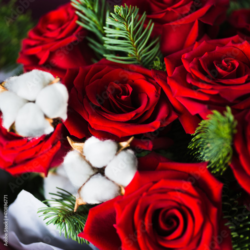 Burgundy bouquet with red roses, green branches of a christmas tree and white flowers