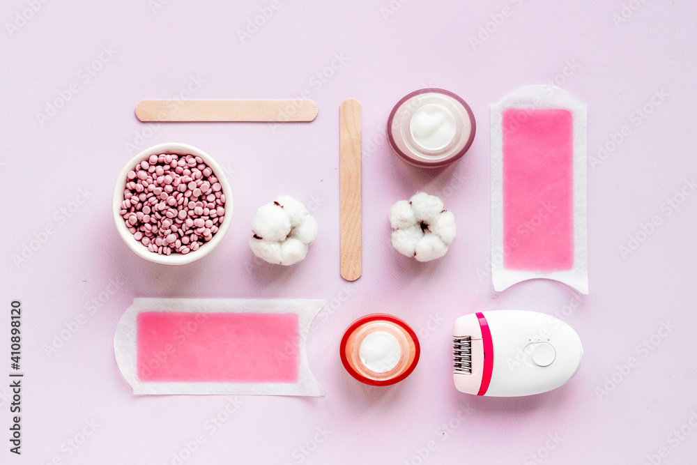 Set of epilation means - epilator with wax strips, razor and flowers. Top view Set of epilation means - epilator with wax strips, razor and flowers. Top view