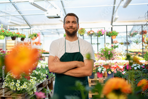 Foto happy worker growing flowers in a greenhouse of a flower shop