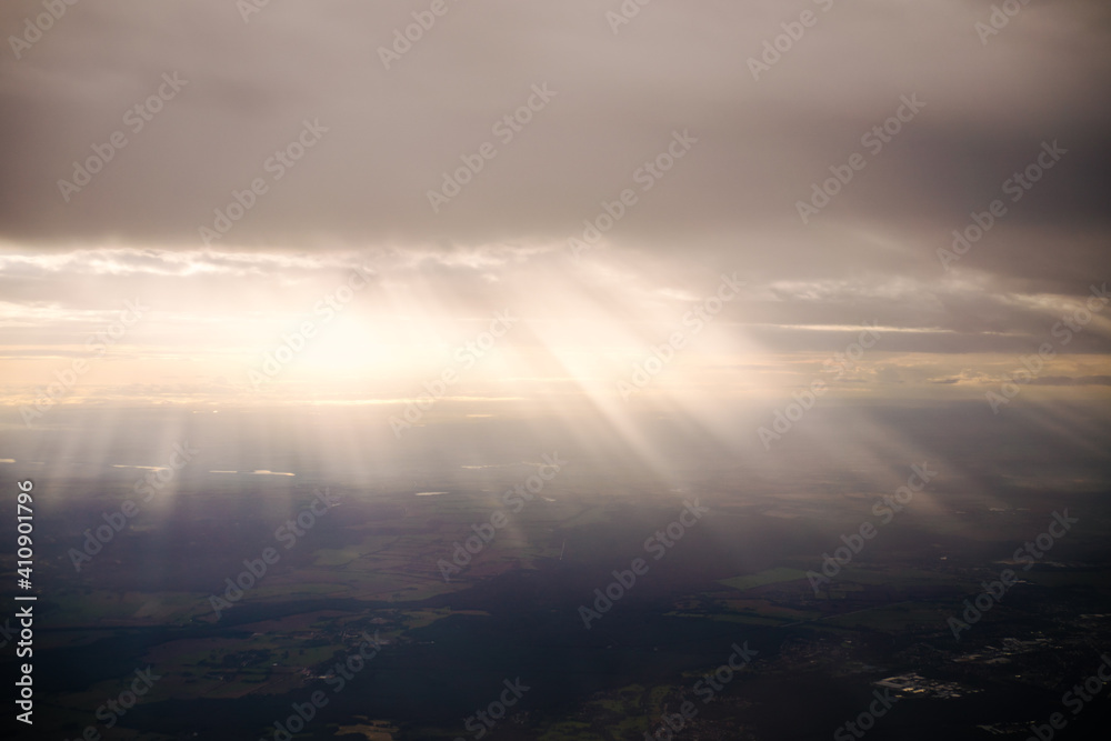 beams of sun light through the clouds on the hills