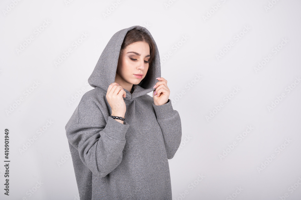 Young girl in a gray sweatshirt with a hood on her head Young girl in a gray sweatshirt with a hood on her head
