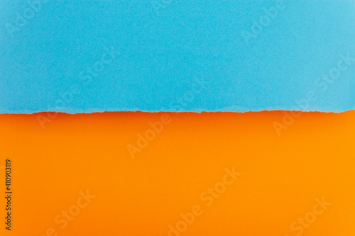 Ripped paper edge with copy space, blue and orange color background. Flat lay. Copy space.