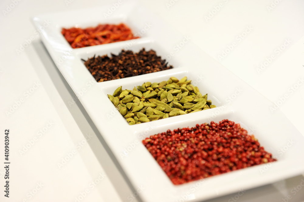 Spices placed in a white plate waiting to be used in the kitchen. Product photography. Spices placed in a white plate waiting to be used in the kitchen. Product photography.