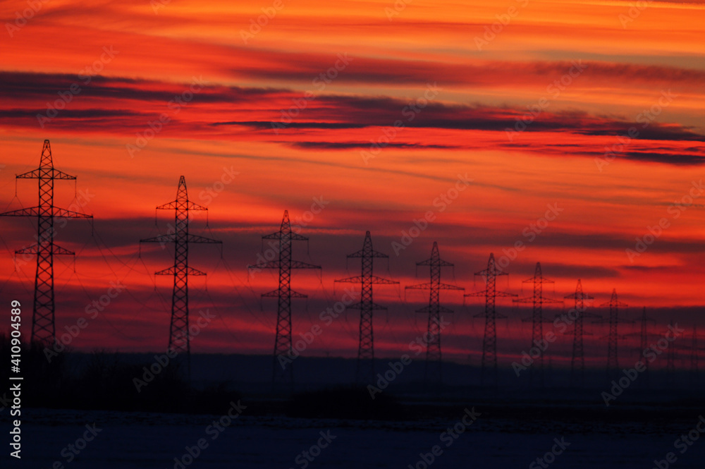 High voltage poles photographed at a beautiful sunset. Red background.