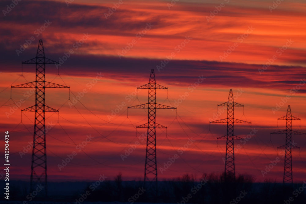 High voltage poles photographed at a beautiful sunset. Red background.