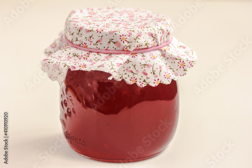 Glass  jar of red currant jam on white background. Preserved berries. Isolated, copy space