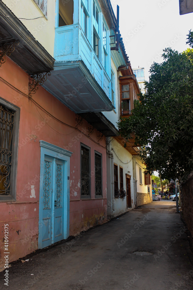 Old traditional houses in a narrow street in Old Town, Antalya, Turkey. Blue wooden door and bay window of house. Old traditional houses in a narrow street in Old Town, Antalya, Turkey. Blue wooden door and bay window of house.